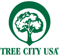 Tree City USA logo, green tree surrounded by a green circle with the text Tree City USA (R) 